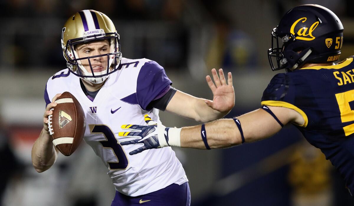 Washington quarterback Jake Browning, left, is pressured by California's Cameron Saffle during the game on Saturday.