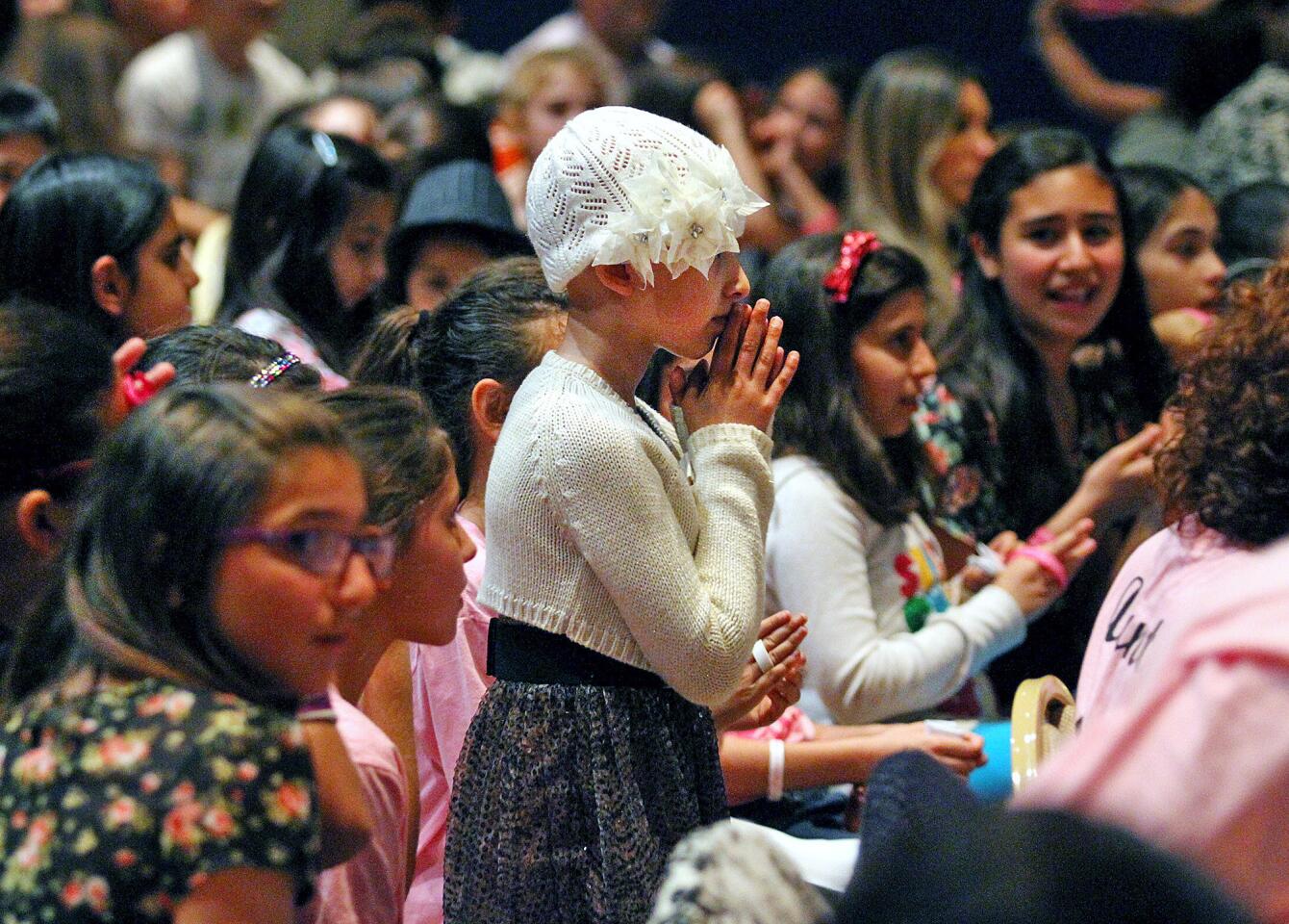 5th grader Grace Kesablak brings her hands to her face during a at the Homenetmen Ararat Chapter in Los Angeles at a benefit concert in her honor on Monday, March 24, 2014. Grace, a Chamlian Armenian School student, underwent her last treatment for cancer recently, and the benefit concert, hosted by TV host Diana Madison, included a magic act by John Gabriel, a song and dance performance by Luara Melody, and Sebu Simonian of Capital Cities who sang "Safe and Sound". Hundreds of friends and family attended the concert. (Tim Berger/Staff Photographer)