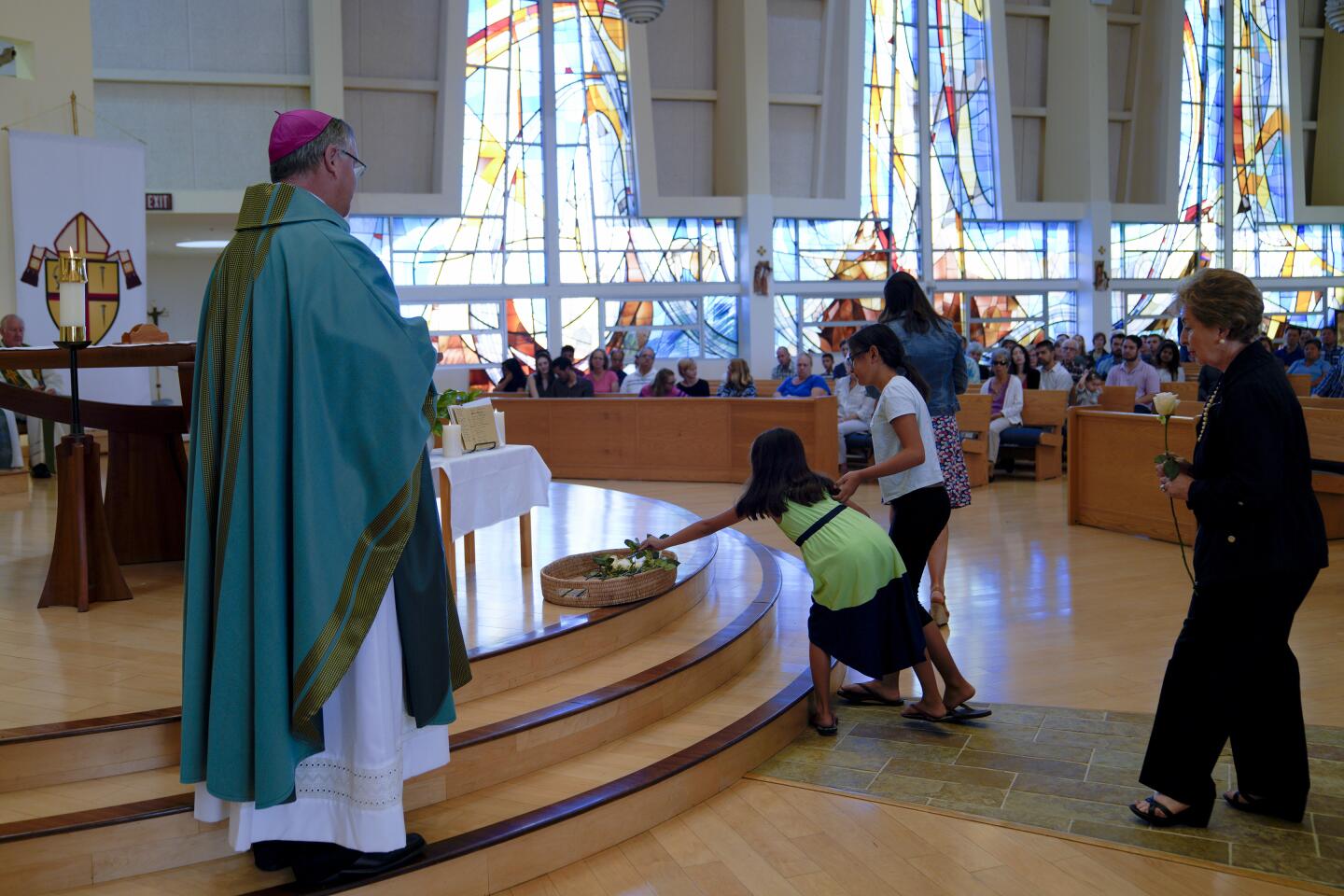 Rev. John P. Dolan, auxiliary bishop of the Roman Catholic Diocese of San Diego stood at the alter as 75 white roses were placed in a basket from families representing a suicide loss in their family.