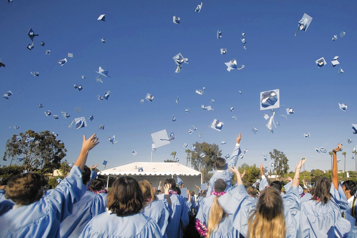 Corona del Mar High School seniors are seen throwing their caps after graduating in 2015. This year's class will have a virtual ceremony because of the COVID-19 pandemic.