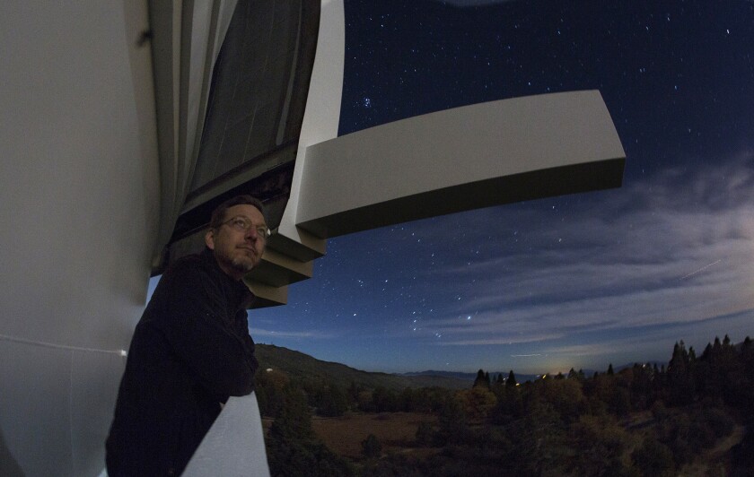 Caltech astronomer Mike Brown stands on the outer catwalk of the Palomar Observatory dome to see if clouds blowing over Palomar Mountain will hamper viewing.