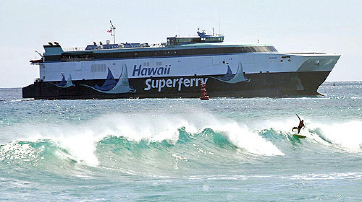 A surfer catches a wave at Kakaako Waterfront Park, with the Hawaii Superferry in the background.