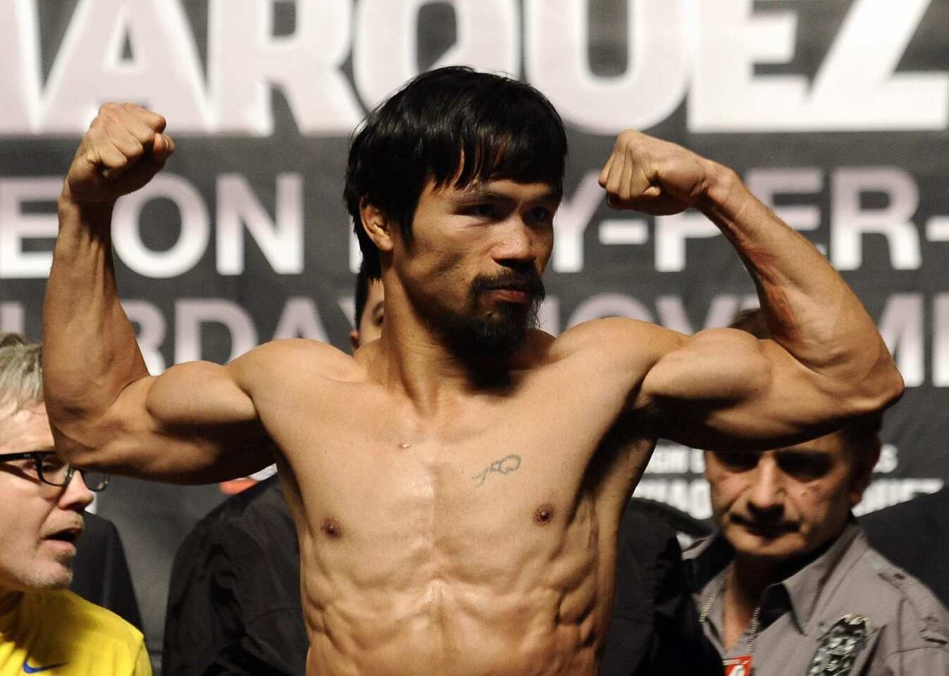 Manny Pacquiao flexes his muscles after weighing in at 143 pounds on Friday at the MGM Grand Garden Arena in Las Vegas. Pacquiao will fight Juan Manuel Marquez for the third time on Saturday, with the winner taking the WBO welterweight title.