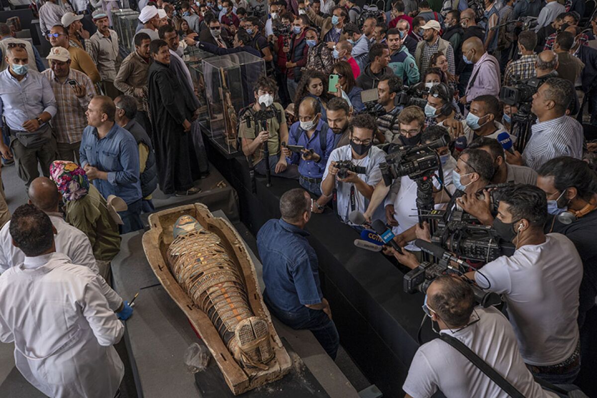 Journalists gather near an ancient sarcophagus at a famed necropolis in Egypt.