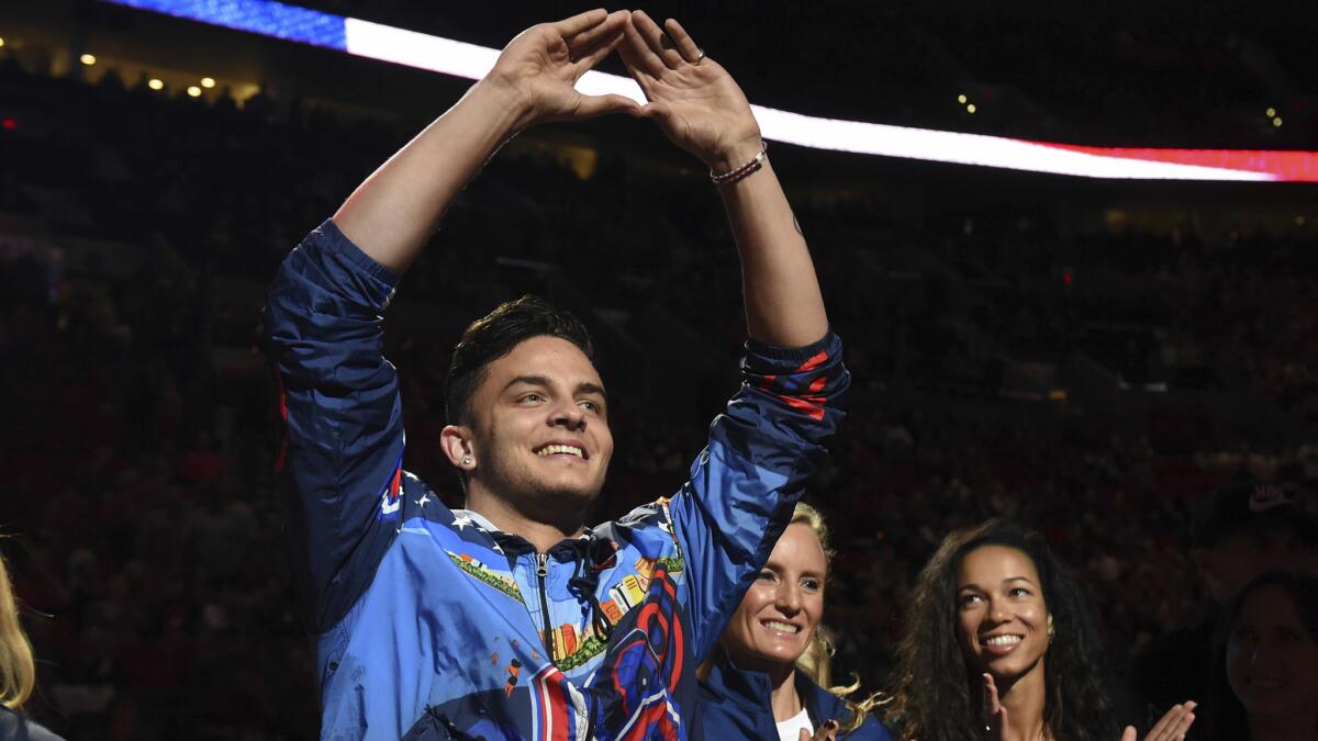 Devon Allen acknowledges the crowd as Olympians from Oregon are honored during a Trail Blazers game on Tuesday.