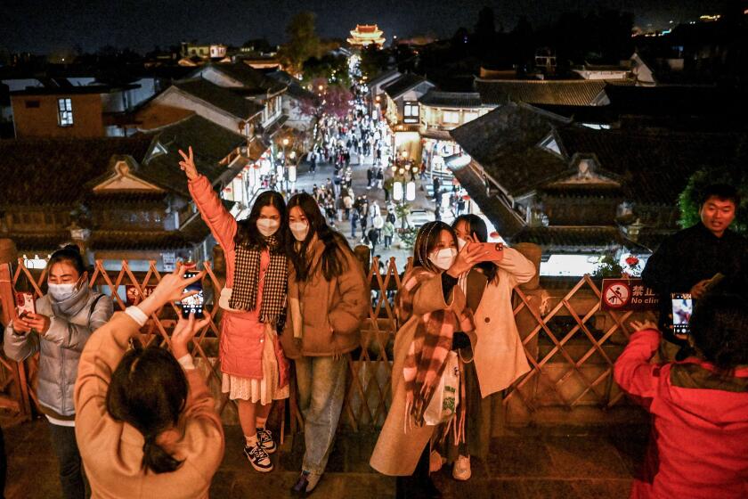 TOPSHOT - This photo taken on January 14, 2023 shows people posing for photos in Dali town, a township-level division in Dali City, in China's northwest of Yunnan province. - Armed with selfie sticks and freshly recovered from Covid, Chinese tourists ambled through bar streets in the country's southwest backpacker haven of Dali, partying the stress of the past three years into oblivion. - To go with AFP story China-tourism-Dali-health-virus,SCENE by Jing Xuan TENG (Photo by Noel CELIS / AFP) / To go with AFP story China-tourism-Dali-health-virus,SCENE by Jing Xuan TENG (Photo by NOEL CELIS/AFP via Getty Images)