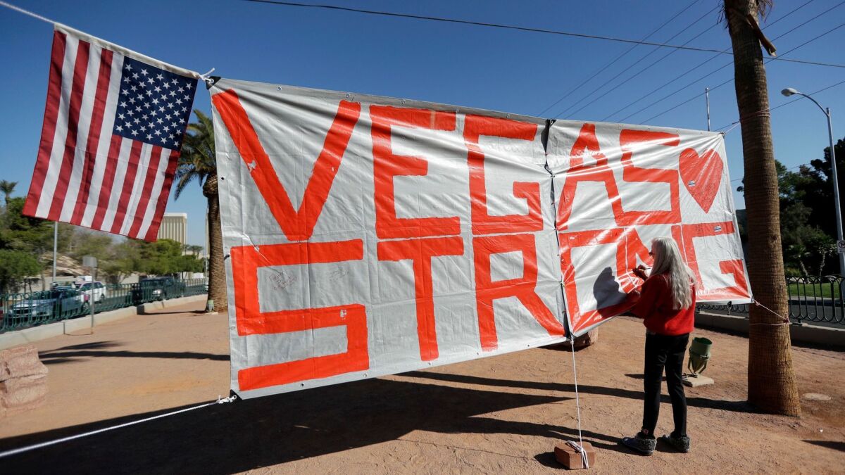 Las Vegas resident Nancy Cooley signs a Vegas Strong banner honoring the victims of a mass shooting in Las Vegas on Oct. 5, 2017.