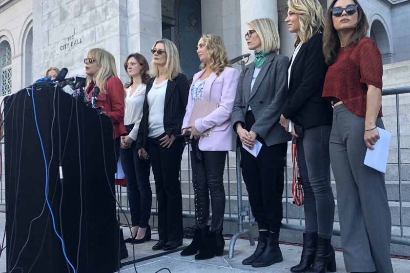 On the morning after Harvey Weinstein's conviction in Manhattan, actress Rosanna Arquette stands with a dozen other women who have accused the producer of sexual assault at a press conference at Los Angeles City Hall.