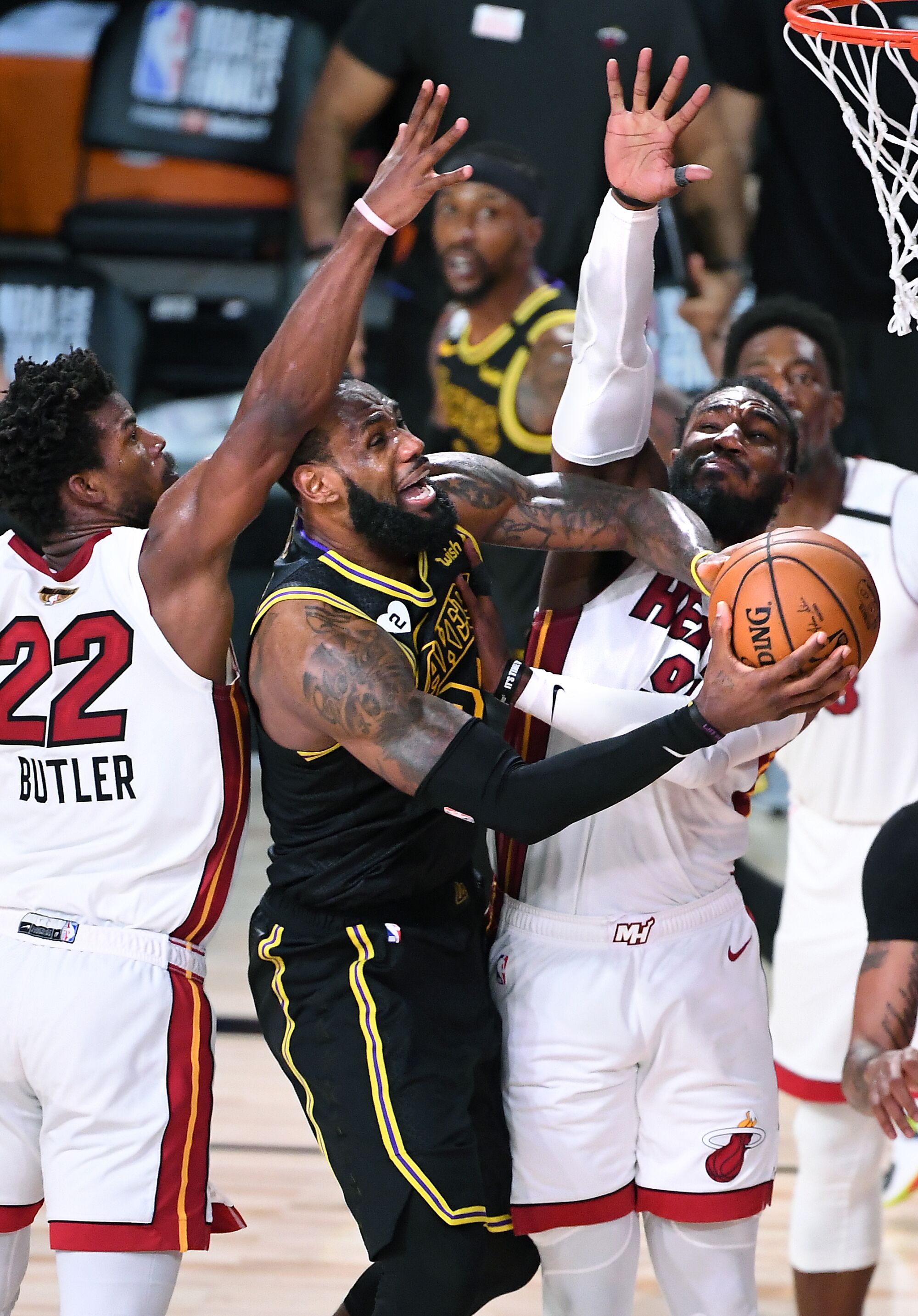 Lakers forward LeBron James misses a shot between Miami Heat forwards Jimmy Butler, left, and Jae Crowder.