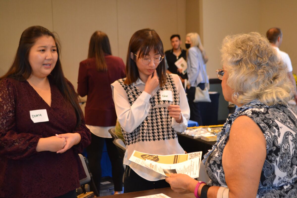 Diana Mei and Chloe Bui of Wealthcentric speak with a participant.