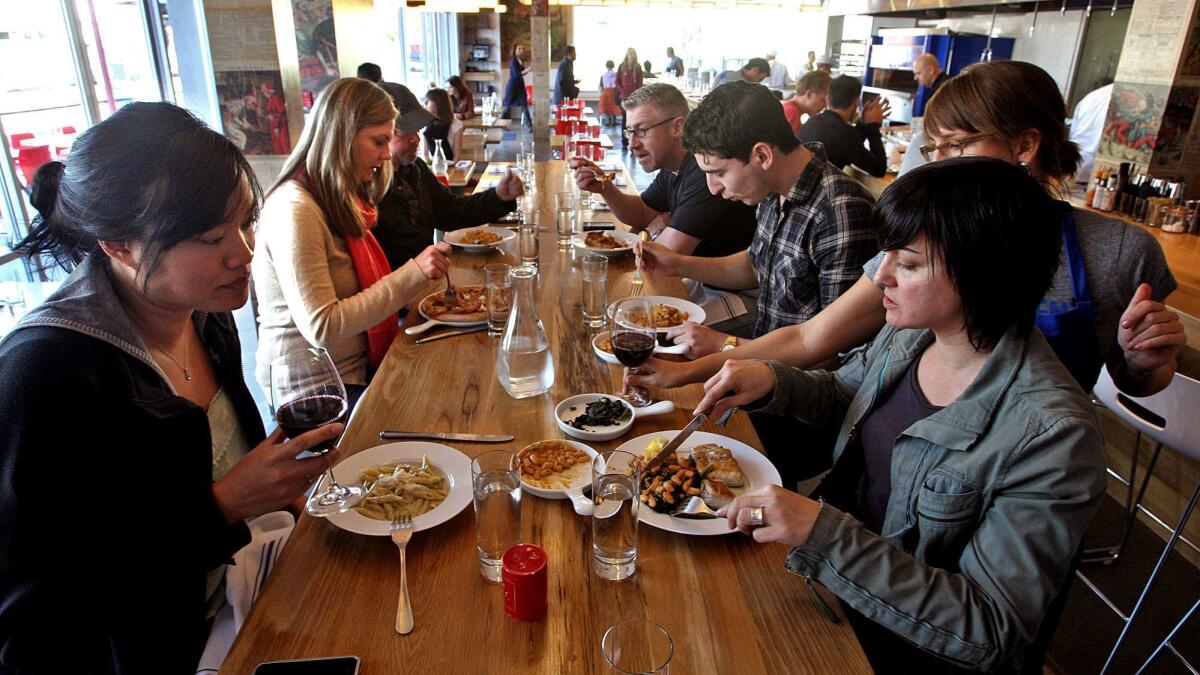 Customers enjoy lunch at a restaurant in Venice. Cutting back on meat and dairy consumption would help cities reduce greenhouse gas emissions associated with food, according to the report.