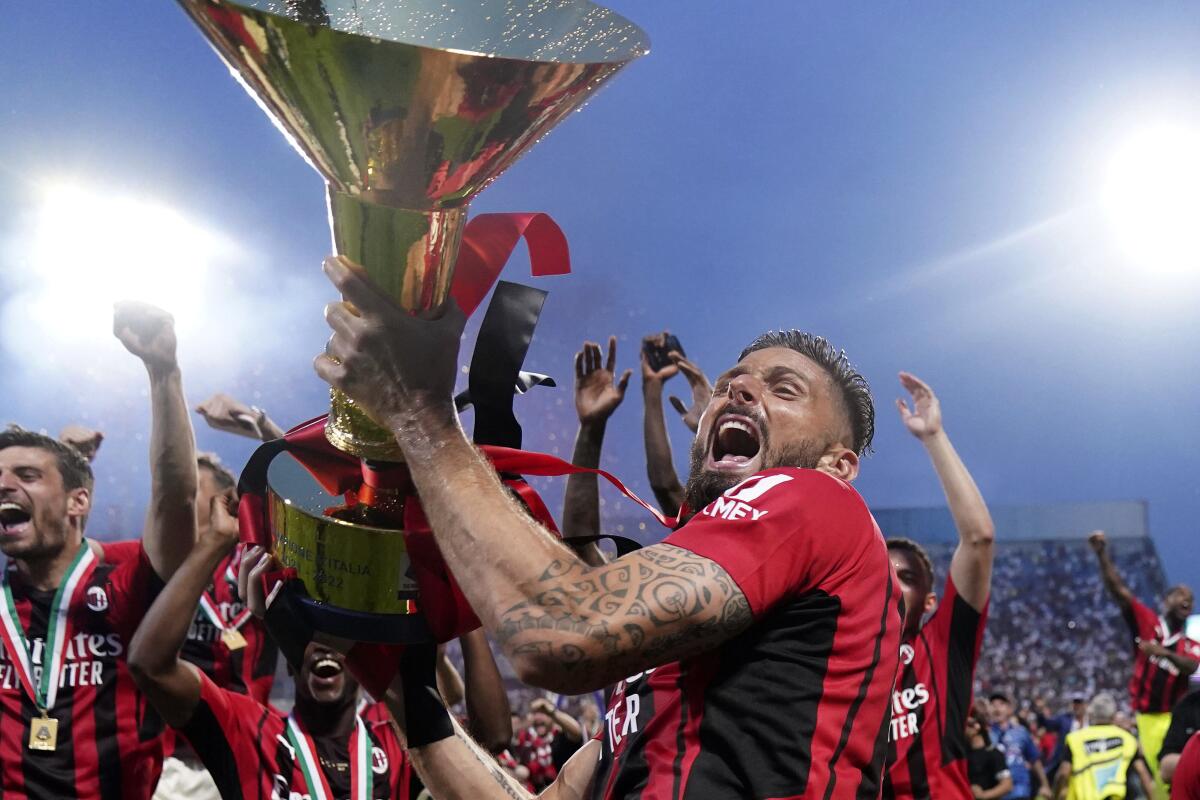 FILE - AC Milan's Olivier Giroud holds the trophy as he celebrates after winning a Serie A soccer match between AC Milan and Sassuolo, in Reggio Emilia's Mapei Stadium, Italy, on May 22, 2022. (Spada/LaPresse via AP, File)