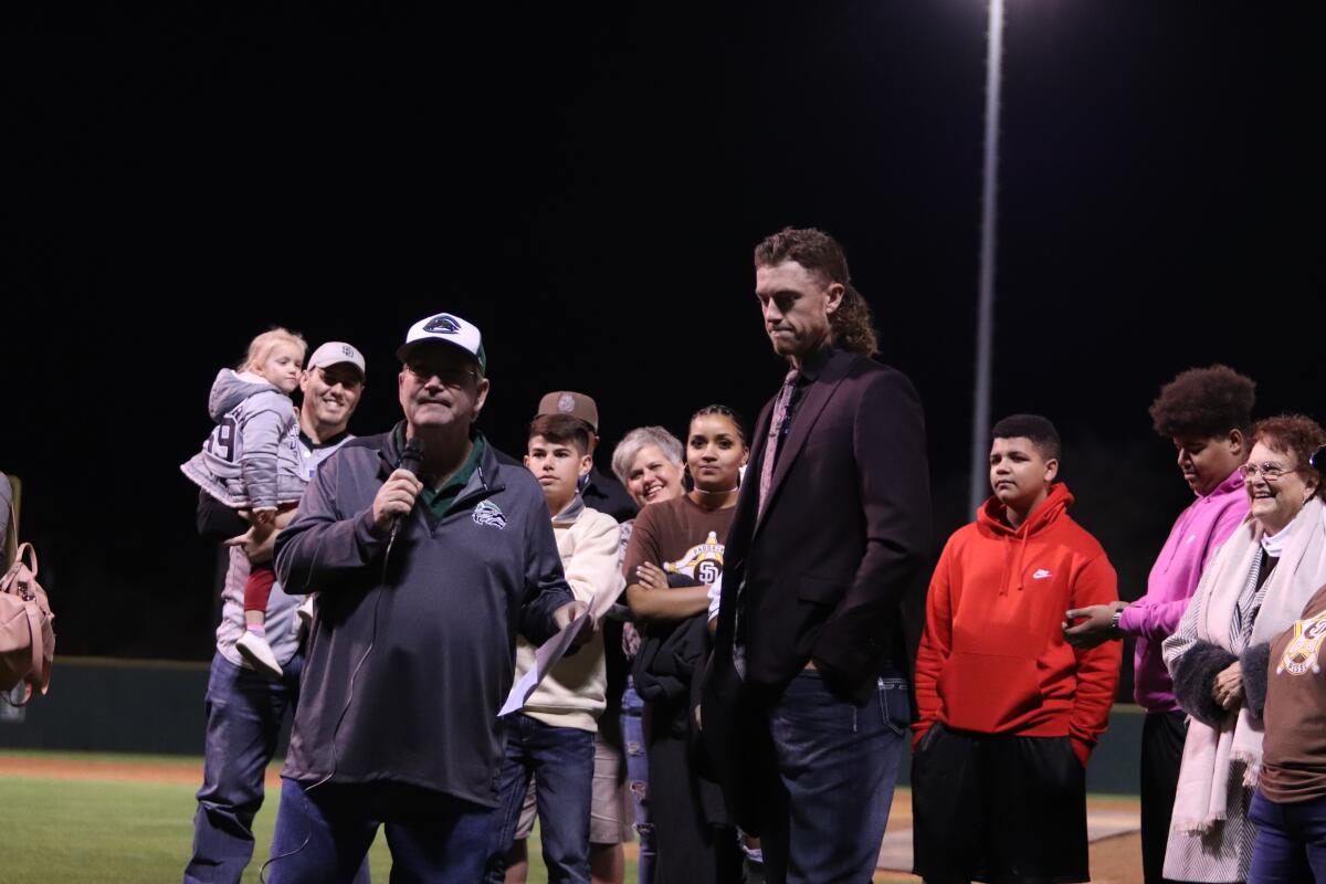 Brad Cone, the radio announcer for Cedar Park High School baseball, introduces Chris Paddack at a ceremony retiring Paddack's high school jersey on Jan. 31. Paddack's family looks on from behind.