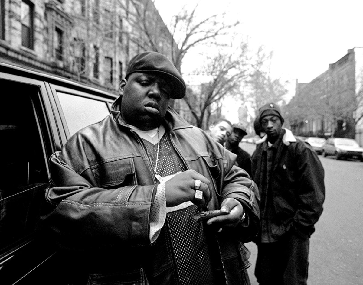 Notorious B.I.G. rolls a cigar outside his mother's house in Brooklyn in 1995.