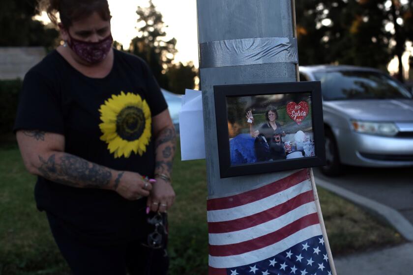 LOS ANGELES, CA - SEPTEMBER 25: Julia Colon visits a vigil for Sylvia Maglia, 63, who was living on the same slab of sidewalk for a couple of years until she died recently in Granada Hills on Friday, Sept. 25, 2020 in Los Angeles, CA. There have been 964 homeless deaths this year, way ahead of last years. (Dania Maxwell / Los Angeles Times)