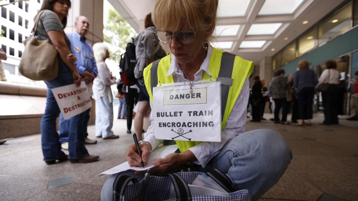 Even before an exact route for the bullet train has been chosen, Californians are protesting its impact. Above, Shannon McGinnis joins a 2015 protest at a California High-Speed Rail Authority meeting in downtown L.A.