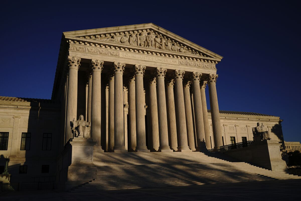 FILE - In this Monday, Nov. 2, 2020, file photo the Supreme Court is seen at sundown on the eve of Election Day, in Washington. The Supreme Court is to hear arguments in a case that could put the brakes on what has been a gradual move toward more leniency for children who are convicted of murder. (AP Photo/J. Scott Applewhite, File)