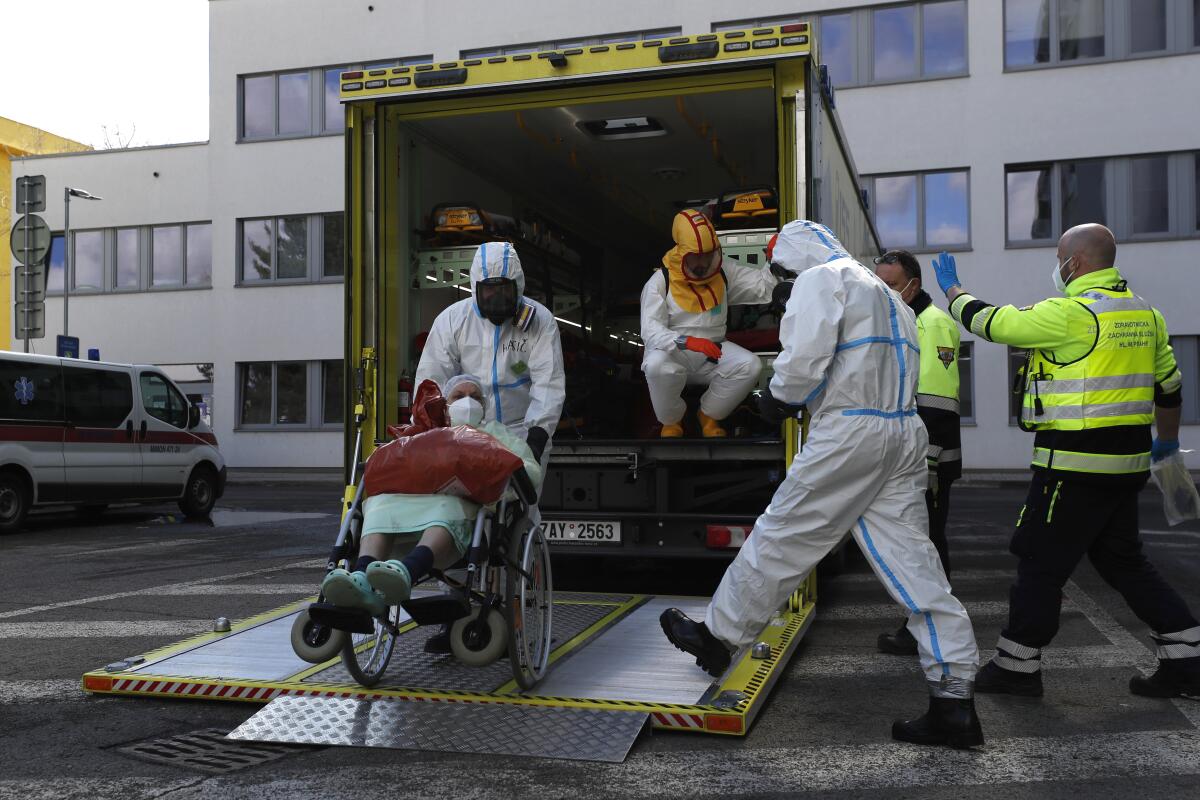 Trabajadores de la salud transportan a un enfermo de COVID-19 en Ceska Lipa, República Checa.