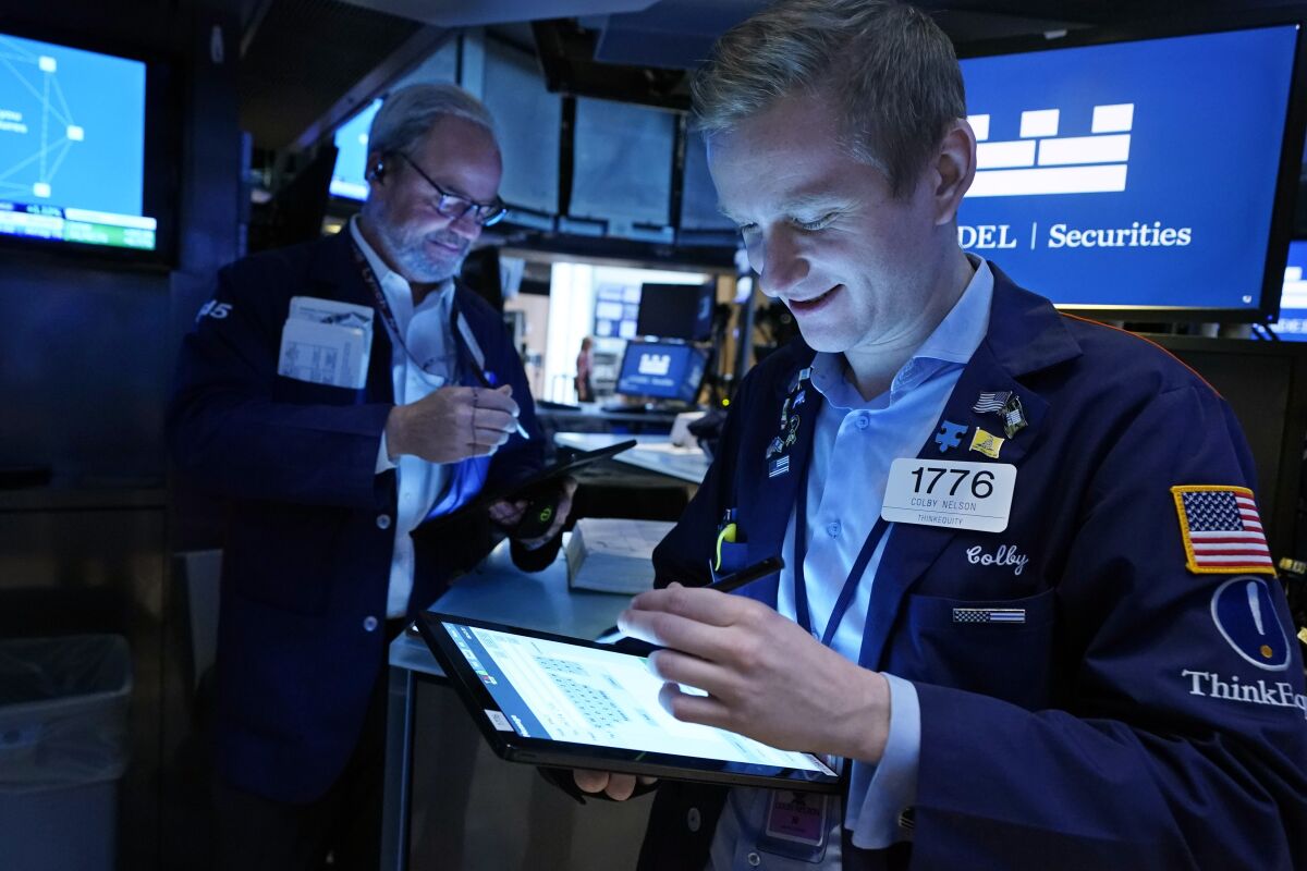 Traders David O'Day, left, and Colby Nelson work on the floor of the New York Stock Exchange, Wednesday, Dec. 1, 2021. The latest move in Wall Street's jolting roller-coaster ride is back up, as stocks, oil and bond yields climb in early Wednesday trading to recover some of their sharp losses from the day before. (AP Photo/Richard Drew)