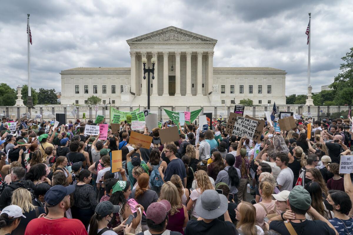 A large group of protestors gathers outside a courthouse.