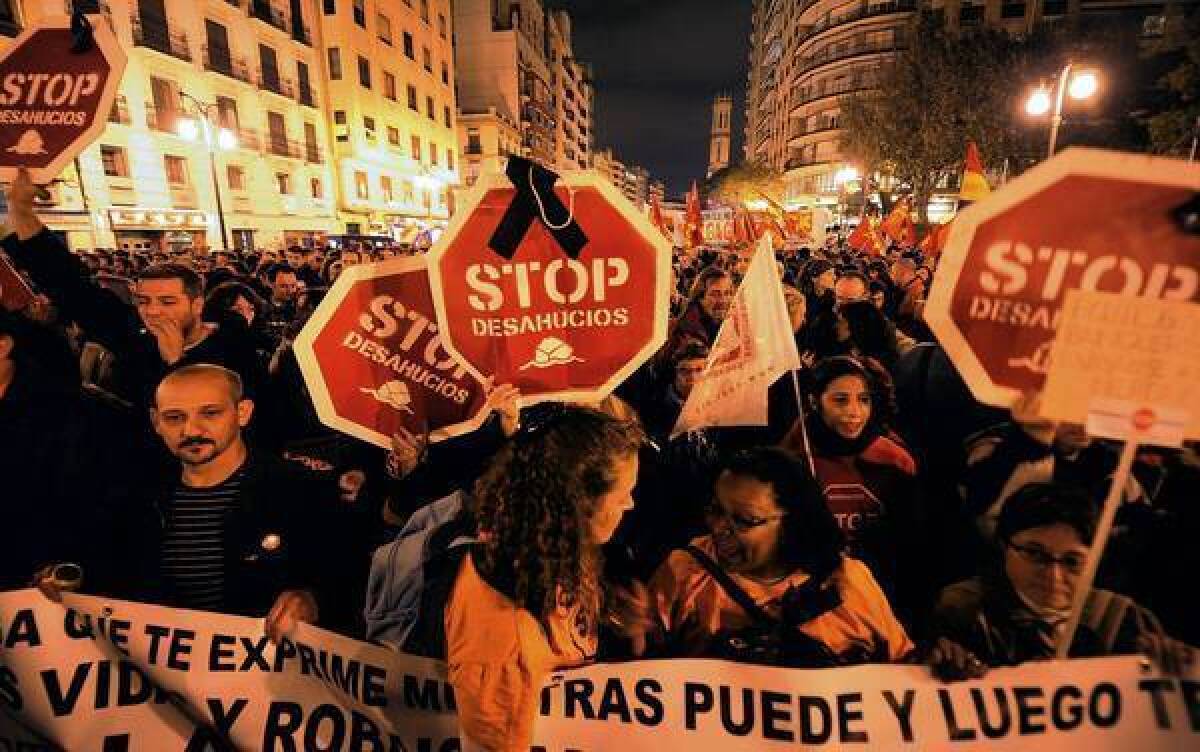 Protesters hold placards reading "Stop evictions" as they attend a demonstration during a general strike in Valencia, Spain.