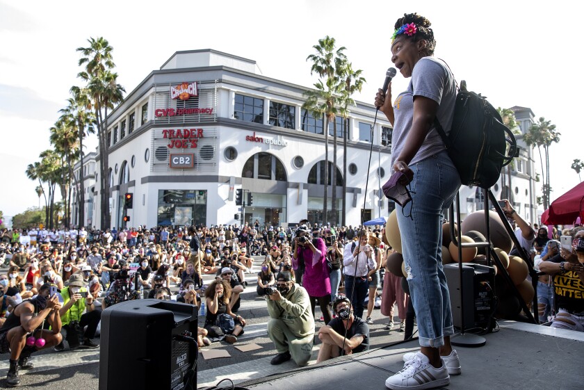 Comedian Tiffany Haddish holds a mic and addresses a crowd