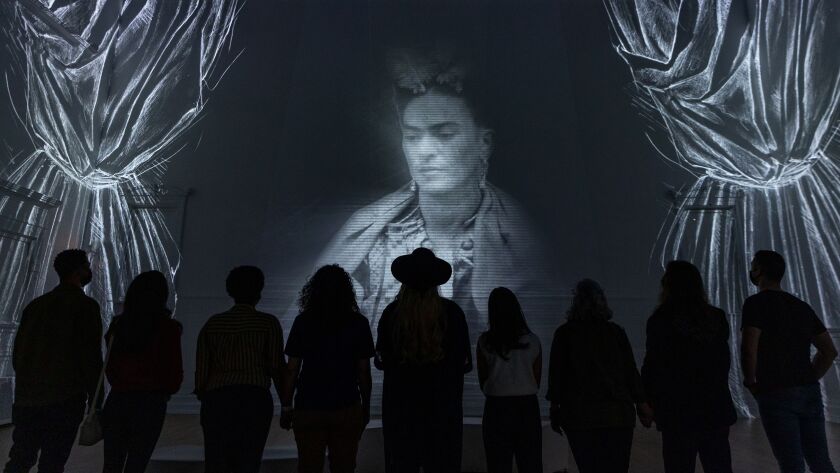 Guests view the artist's self portrait in “Immersive Frida Kahlo,” at Lighthouse Artspace in Chicago, in February.