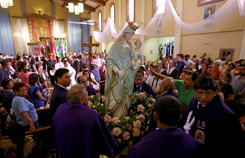 A group of men belonging to the Queen of Angels Foundation carry a statue of the Virgin Mary out of La Placita Church in Los Angeles before parading it through the streets to the Cathedral of Our Lady of the Angels on Sept. 14.
