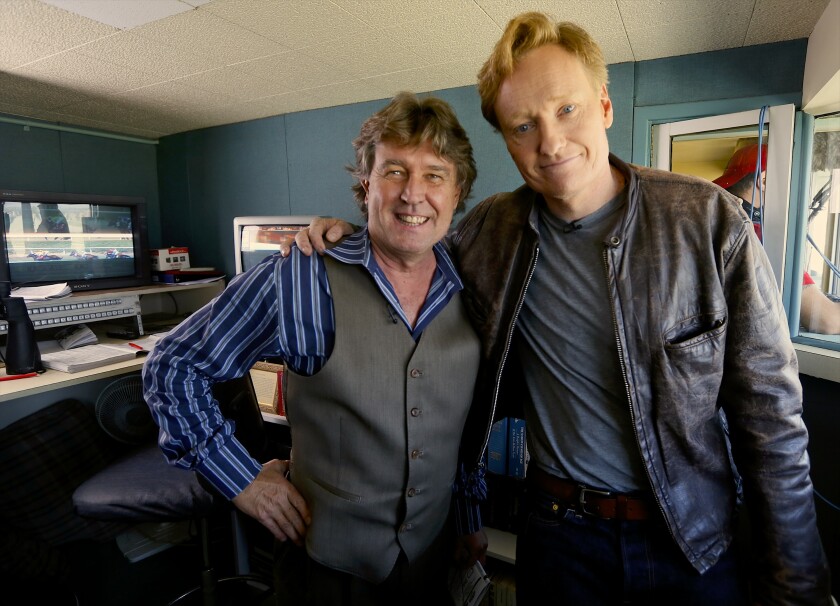 Television host Conan O'Brien, right, poses for a photo with track announcer Trevor Denman