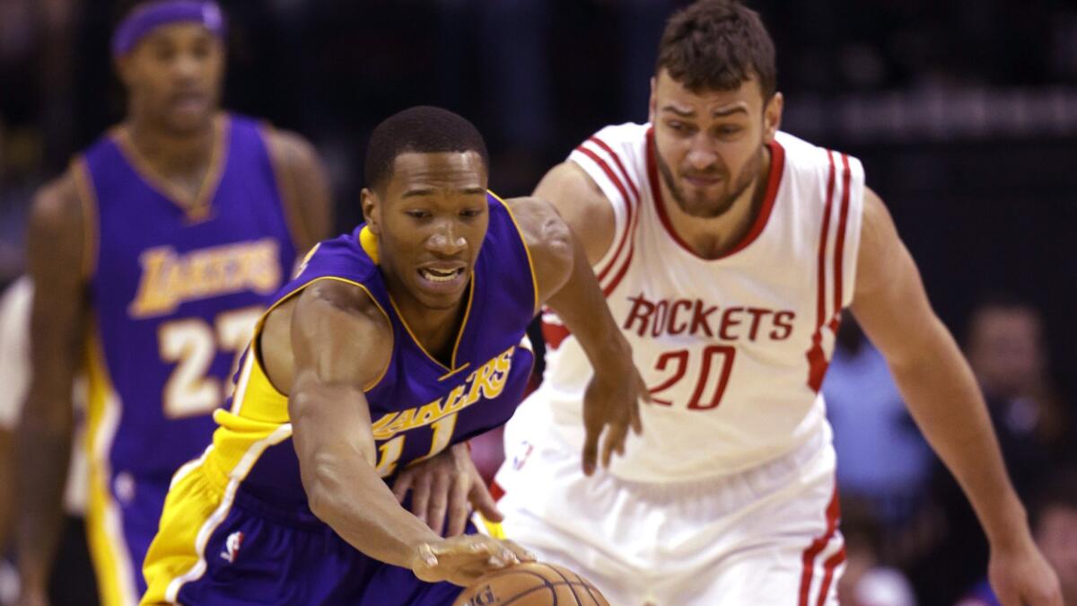 Lakers forward Wesley Johnson and Houston Rockets forward Donatas Motiejunas chase after the ball during the first half of a game Nov. 19 in Houston.