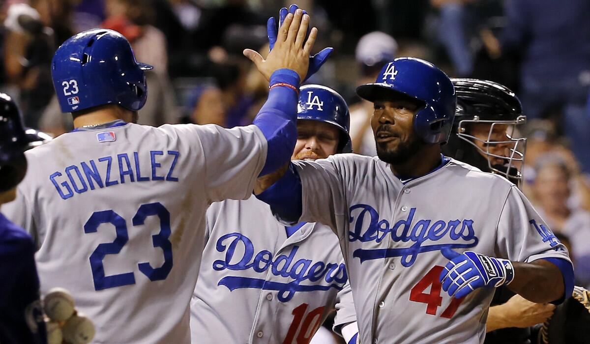 Los Angeles Dodgers' Howie Kendrick celebrates his three-run home run against the Colorado Rockies with teammates Adrian Gonzalez and Justin Turner at home plate during the eighth inning on Monday.