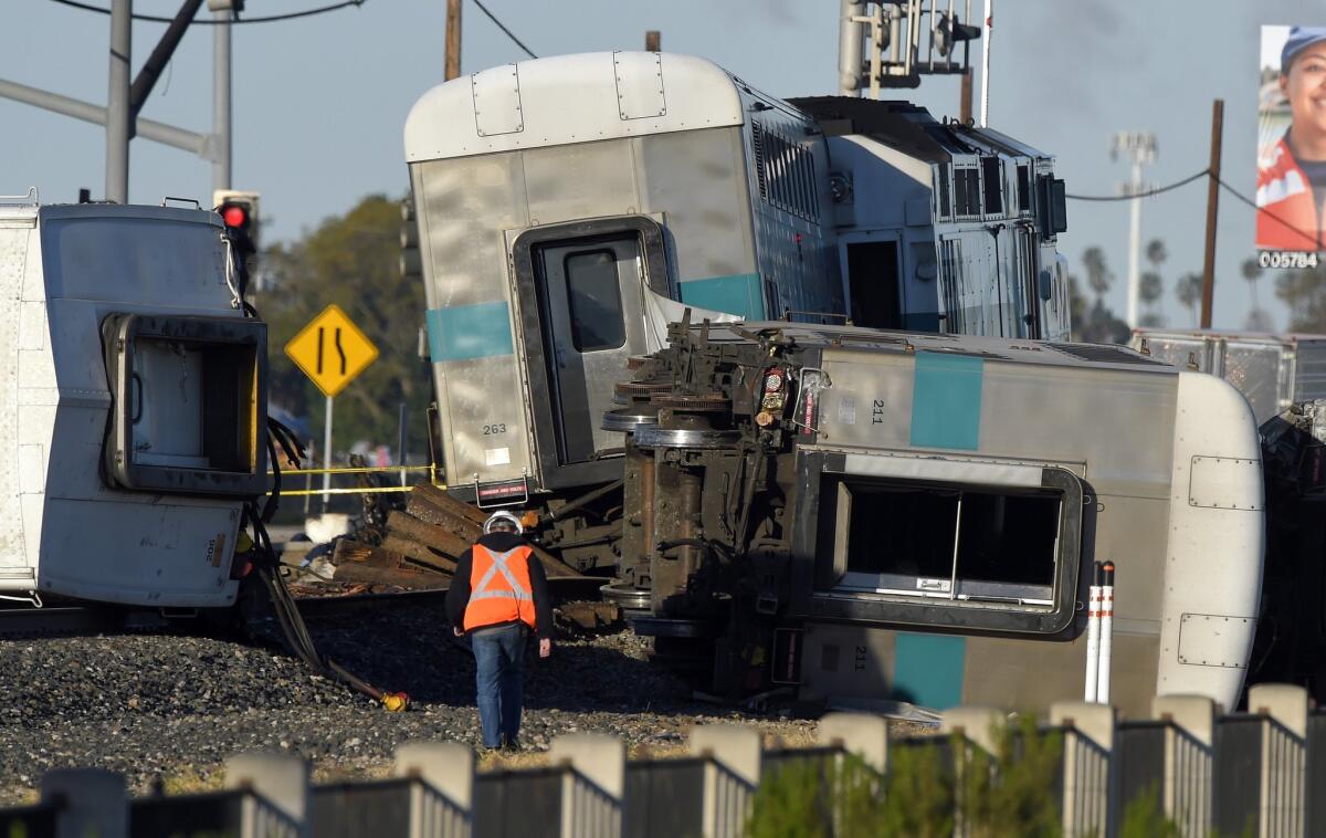 A worker walks along the tracks near the wreck of a Metrolink passenger train that derailed in Oxnard, Calif. on Feb. 24.