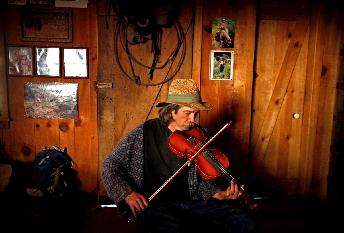 Using a bow that his father made, Dennis English plays "My Mother's Waltz," a song that he wrote after Mary English died in 2001. Dennis, 51, is an accomplished fiddle player. His father's bows are prized among violin, viola, cello and bass players in the Santa Cruz area.