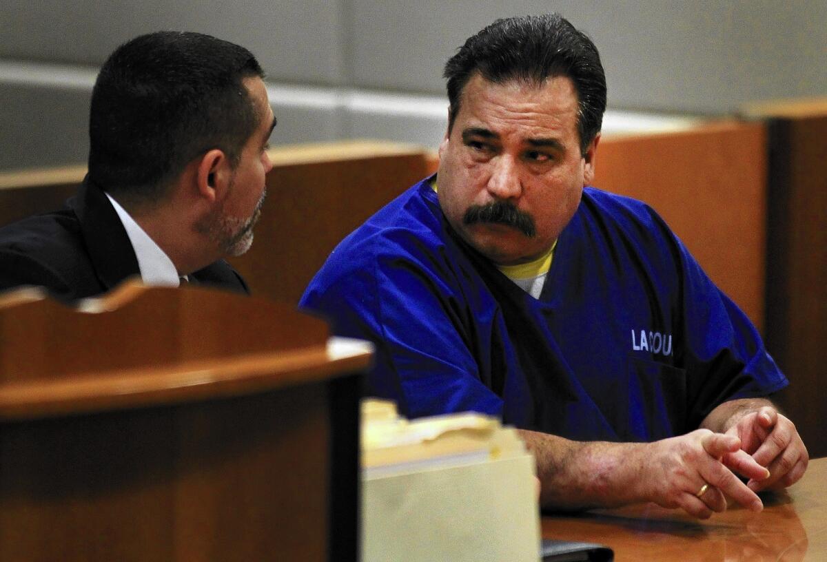 Leonard Alex Dominguez, right, speaks with his attorney, Victor Acevedo, during his sentencing Wednesday in the 1979 killing of Sandra Phillips.