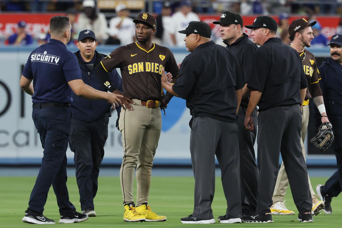 Padres left fielder Jurickson Profar talks with umpires and Dodger Stadium security officials during the seventh inning.