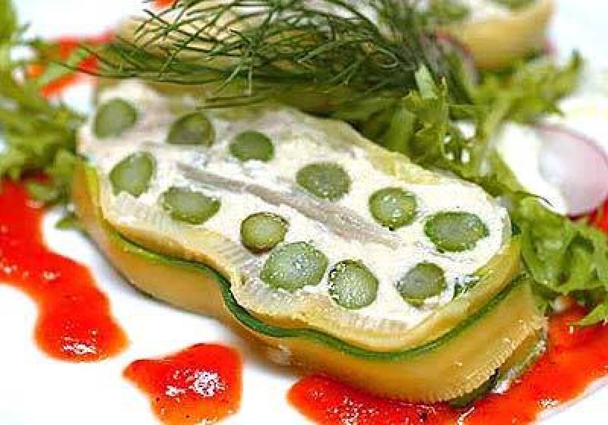 Leeks and artichoke hearts, as well as asparagus and fennel, are layered with cashew cheese, encased in zucchini and drizzled with tomato coulis in Chaya Brasseries green terrine.