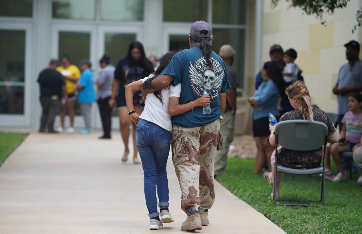 Family members walk with their arms around each other.