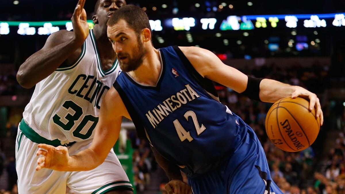 Minnesota's Kevin Love, right, drives past Boston's Brandon Bass during a game in December. Love was traded to the Cleveland Cavaliers on Saturday.