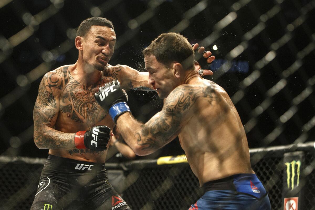 Max Holloway, left, fights Frankie Edgar during a mixed martial arts bout at UFC 240, in Edmonton, Alberta, on Saturday, July 27, 2019. (Jason Franson/The Canadian Press via AP)