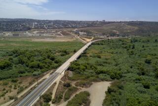 A section of Dairy Mart Road that bridges over the Tijuana River in south San Diego with U.S. Mexico border in the background. Earlier today Representatives, Juan Vargas, Susan Davis, Scott Peters, Mike Levin and Imperial Beach Mayor, Serge Dedina held a press conference at Bayside Park on Chula Vista's waterfront, July on Monday, July 22, 2019 to announce the introduction of their Tijuana River Valley Pollution Solution bill.