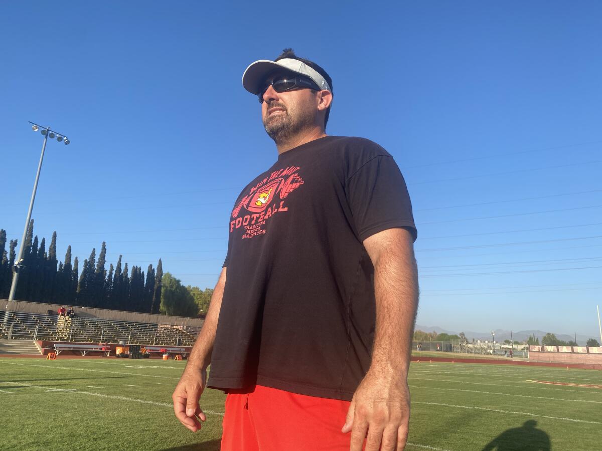 Mission Viejo coach Chad Johnson stands on a football field.