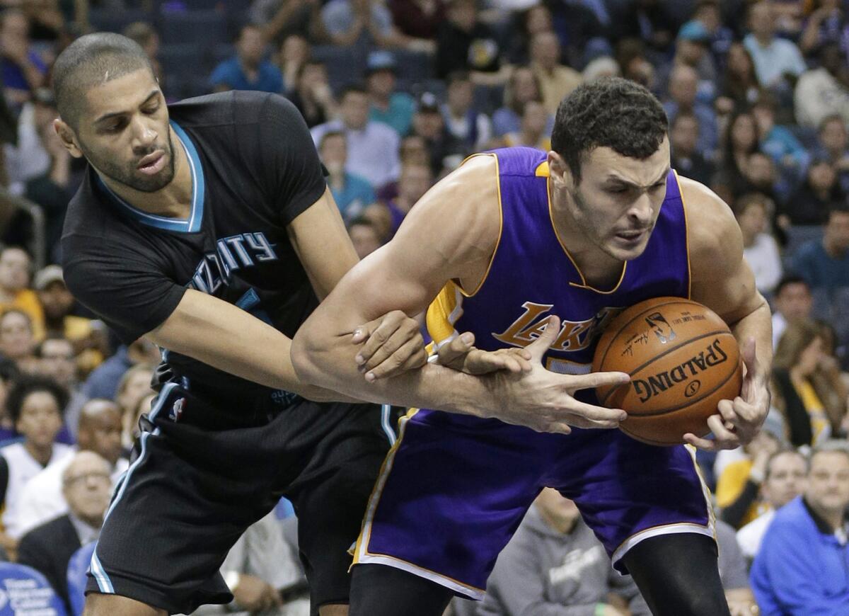 Hornets forward Nicolas Batum, left, reaches in to try to swipe the ball from Lakers forwar Larry Nance Jr., right, in the second half on Dec. 28.