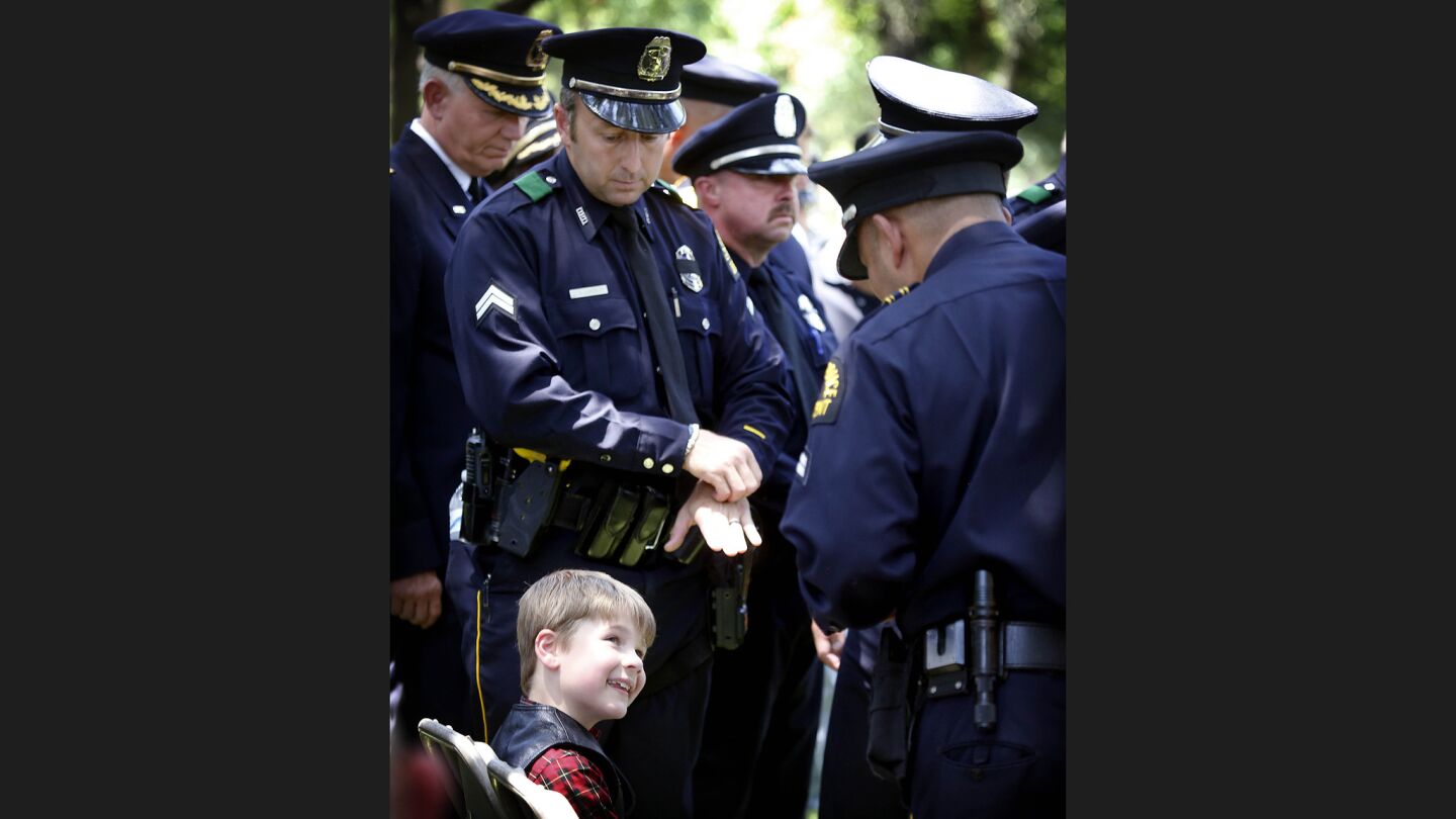 Magnus, the 8-year-old son of slain Dallas Police Officer Lorne Ahrens, speaks to officers after his father's funeral Wednesday. Sr. Cpl. Ahrens was buried at Restland Memorial Park in Dallas.