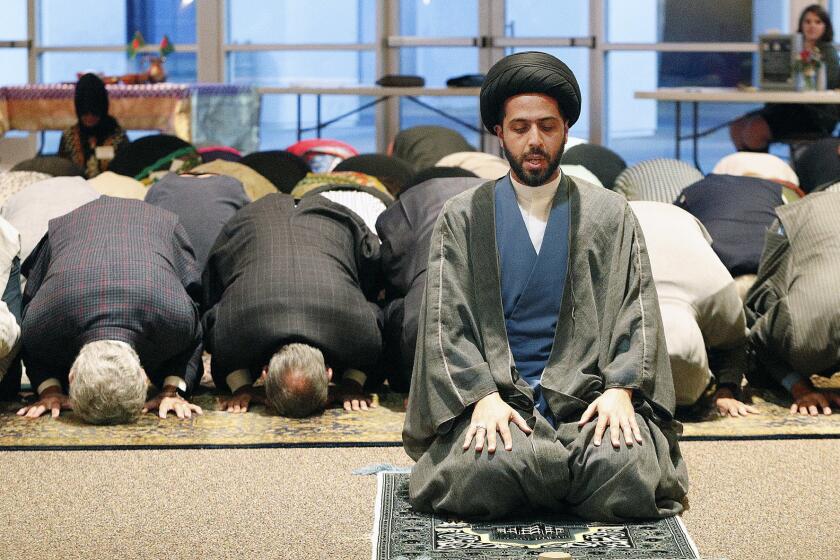 Imam Mahdi al-Qazwini leads a Muslim prayer at the Temple Bat Yahm synagogue in Newport Beach on Thursday during a multi-faith gathering for iftar, a fast-breaking dinner during Ramadan, the Muslim holy month.
