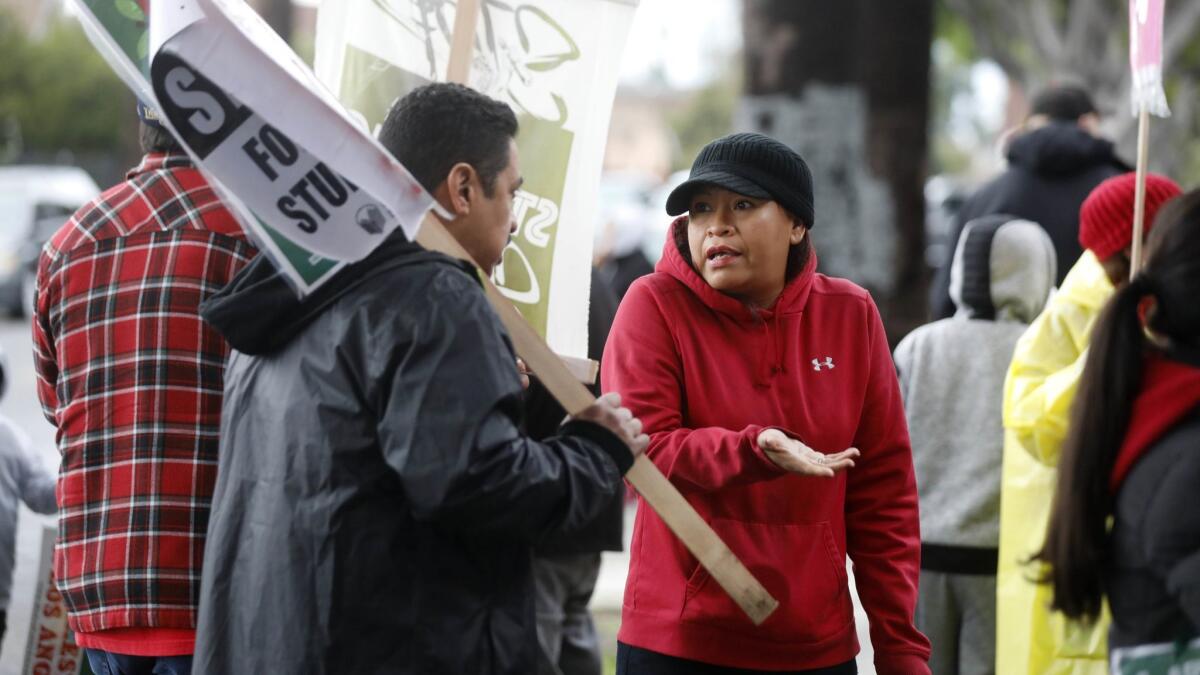 Fifth-grade teacher Jesus Torres talks with parent Angelica Nolasco as LAUSD teachers picket at L.A.'s Trinity Street Elementary.