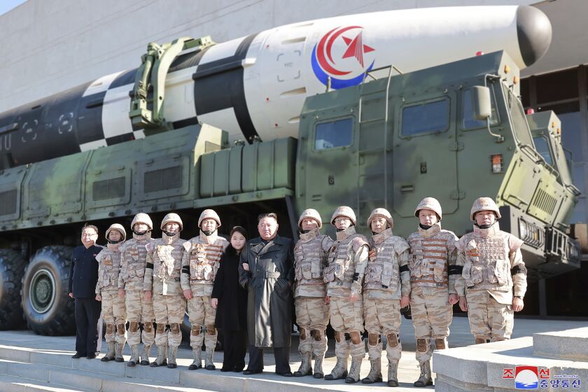 This undated photo provided on Nov. 27, 2022, by the North Korean government shows North Korean leader Kim Jong Un, center, and his daughter, center left, pose with soldiers for a photo, in front of what it says a Hwasong-17 intercontinental ballistic missile, at unidentified location in North Korea. Independent journalists were not given access to cover the event depicted in this image distributed by the North Korean government. The content of this image is as provided and cannot be independently verified. Korean language watermark on image as provided by source reads: "KCNA" which is the abbreviation for Korean Central News Agency. (Korean Central News Agency/Korea News Service via AP)