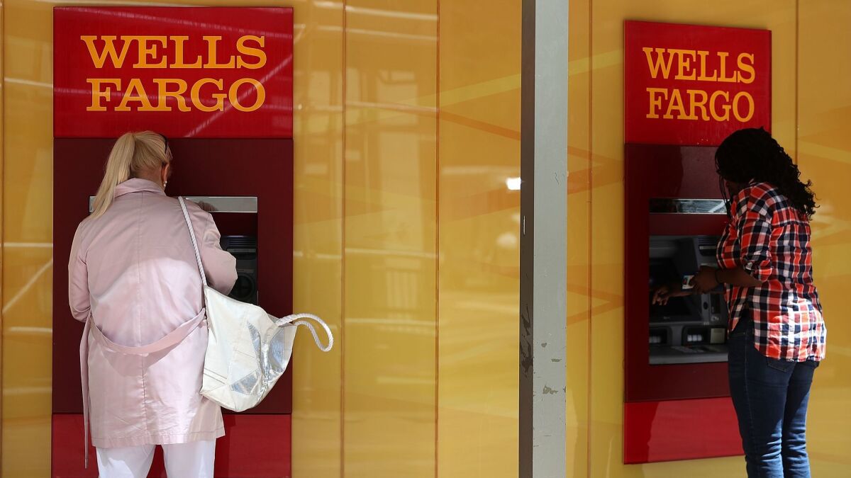 Customers use ATMs at a Wells Fargo Bank branch in San Francisco in July,