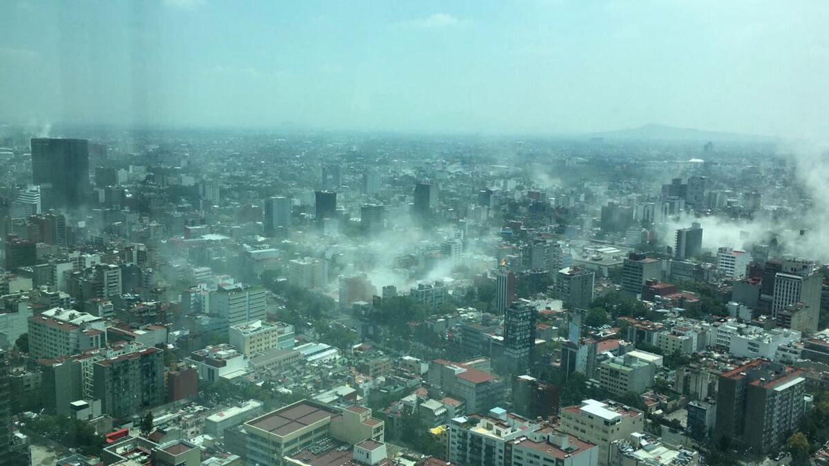 In this photo provided by Francisco Caballero Gout, shot through a window of the Torre Latina, dust rises over downtown Mexico City during a 7.1 earthquake Tuesday.