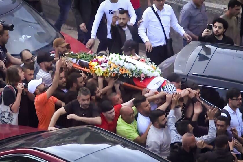 RAMALLAH, PALESTINE - The body of Al Jazeera journalist Shireen Abu Akleh, who was killed Wednesday, was carried to Al Jazeera’s headquarters in the West Bank city of Ramallah as a large crowd chanted outside. (Associated Press)