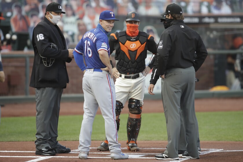 Texas Rangers' Scott Heineman (16) meets his brother Tyler Heineman as they represent their teams with umpires prior to a baseball game Saturday, Aug. 1, 2020, in San Francisco. (AP Photo/Ben Margot)